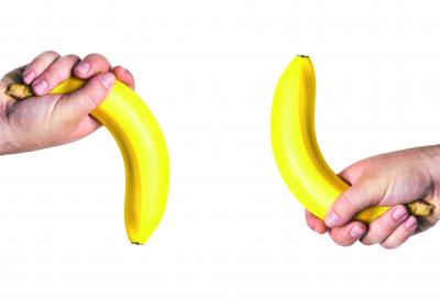 Två händer med varsin banan. En banan pekar ner och den andra upp