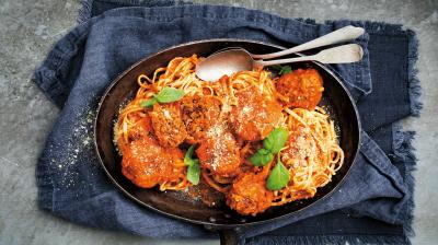 Italienska köttbullar i tomatsås med pasta, toppat med basilika