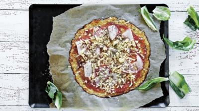 Blomkålspizza med kalkonskivor på en plåt
