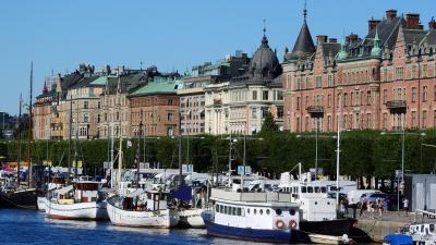 Sommar vy med båtar vid kaj och stadshus i bakgrunden