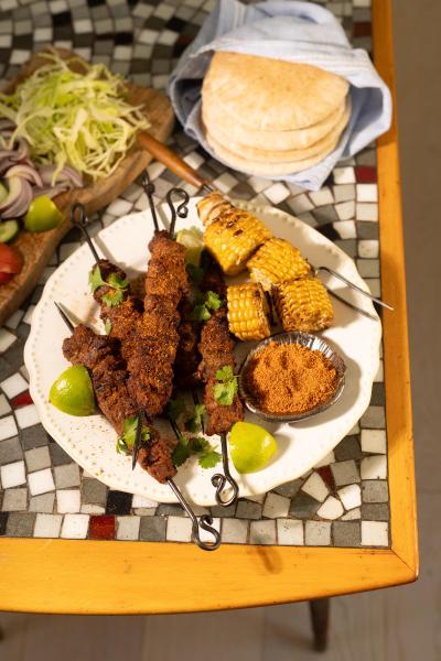 Suya grillat kött med jordnötter och majs på ett fat