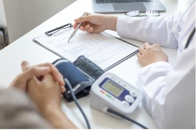 Blodtrycksutrustning_checklista, läkares och patients händer på bordet