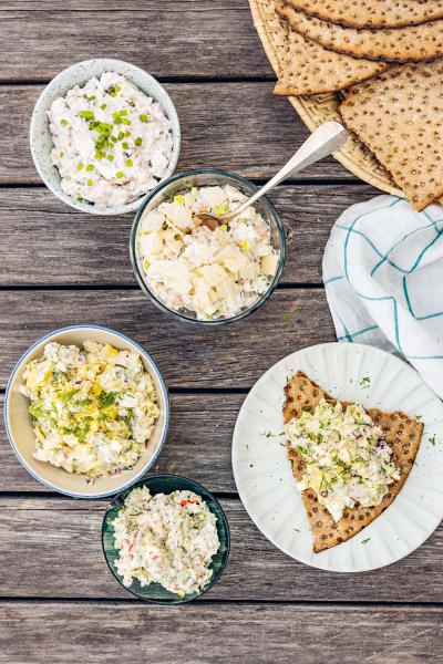 Flera små skolar med röror på ett bord inklusive en med Räkröra med parmesan, äpple och pepparrot och några knäckebrödskivor