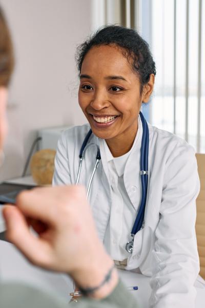 en läkare ler mot sin patient